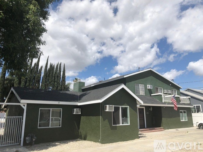 A green house with a white van parked in front.