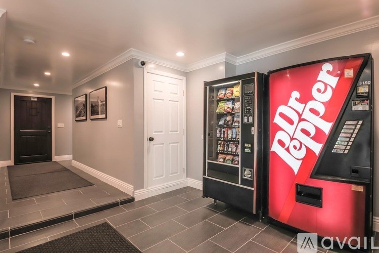A room with a vending machine and a door.