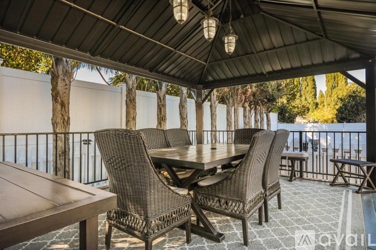 A patio with a table and chairs under a roof.