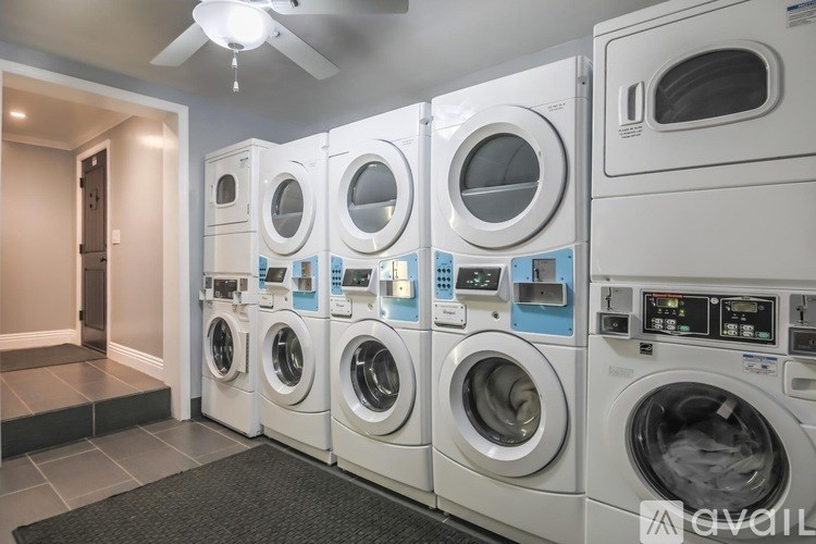A row of white front load washing machines in a laundromat.