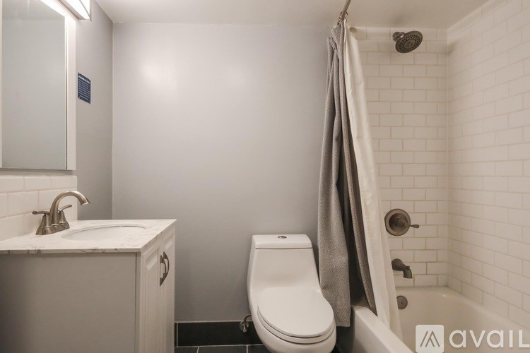 A bathroom with a toilet, sink, and shower.
