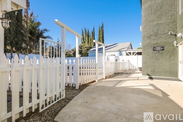 A white fence runs along the side of a house.