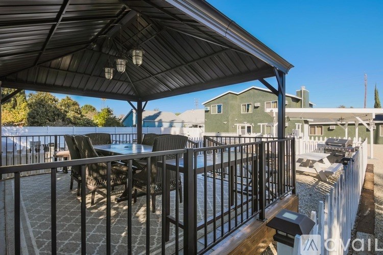 A patio with a table and chairs under a roof.