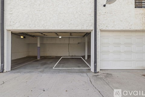 A white garage door is open to reveal a spacious garage.