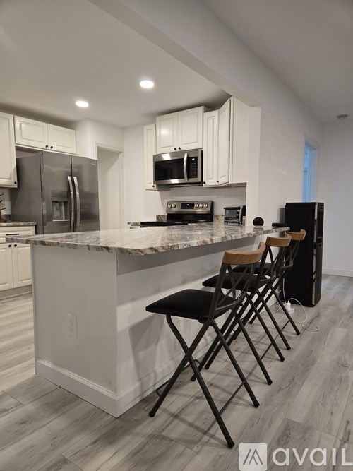 A kitchen with a marble countertop and white cabinets.