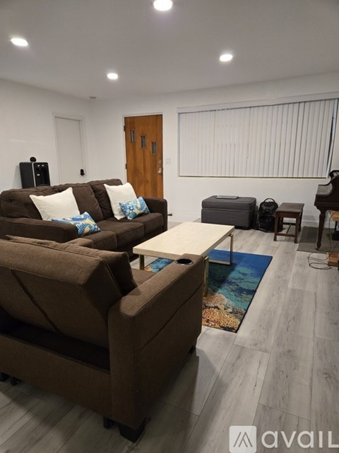 A living room with a brown couch and a white coffee table.