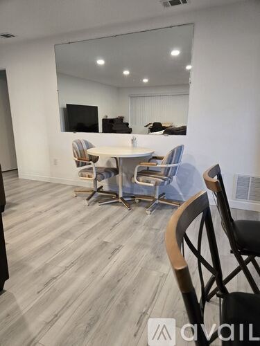 A conference room with a table, chairs, and a television on the wall.