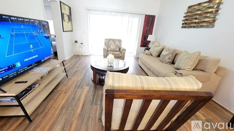 A living room with a television displaying a tennis game.
