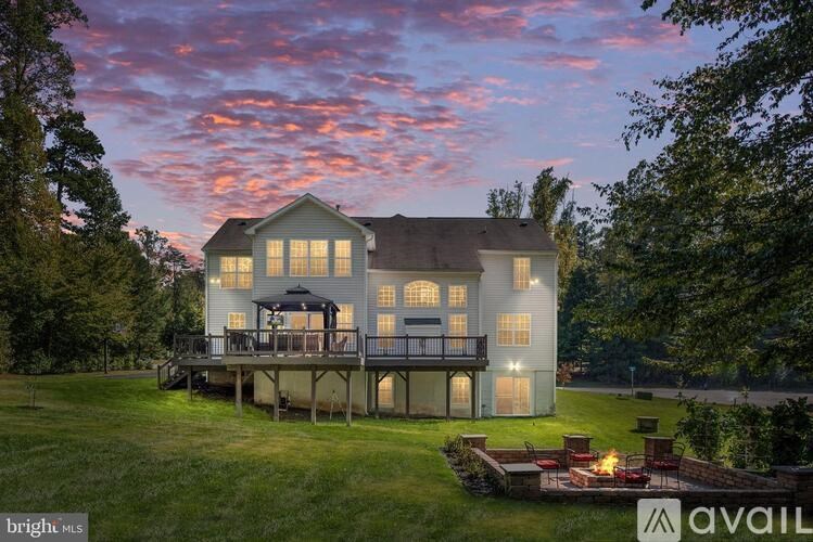A house with a deck and a fire pit in the yard.
