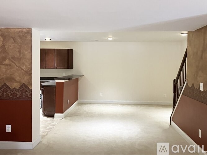 A room with a kitchenette and a staircase.