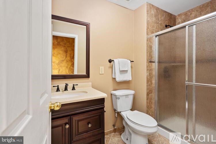 A bathroom with a toilet, sink, and shower.