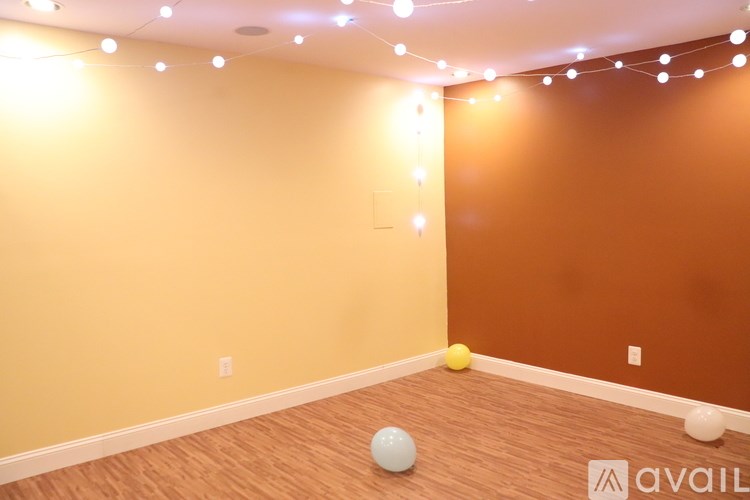 A room with wooden flooring and a wall with a brown and yellow color scheme.