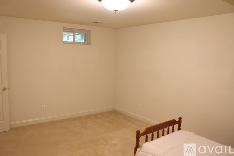 A bedroom with a bed, a window, and a door.