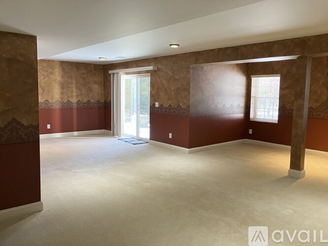 A spacious room with a doorway leading to another room.