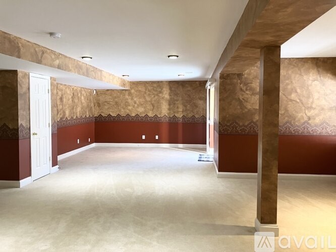 A large empty room with a brown and red wallpaper.