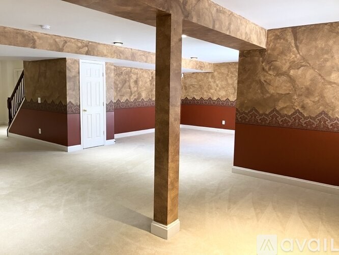 A room with a white door and a brown column.