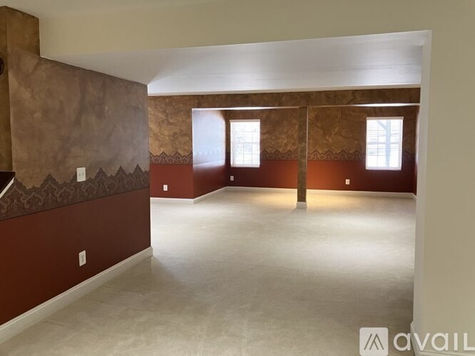 A room with a brown wall and a window.