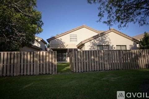 A house with a wooden fence in front of it.