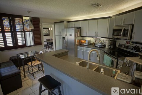 A kitchen with a refrigerator, microwave, and oven.