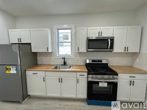 A kitchen with white cabinets and a black stove top oven.