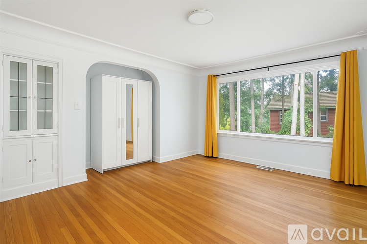 A room with a window and a wooden floor.