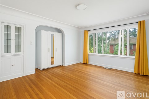 A room with a window and a wooden floor.