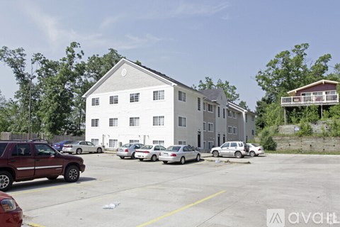 A parking lot with cars and a building in the background.