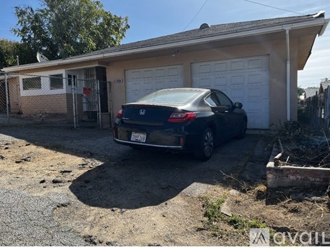 A black Honda Accord is parked in front of a garage.