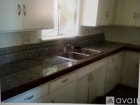 A kitchen with a granite countertop and white cabinets.