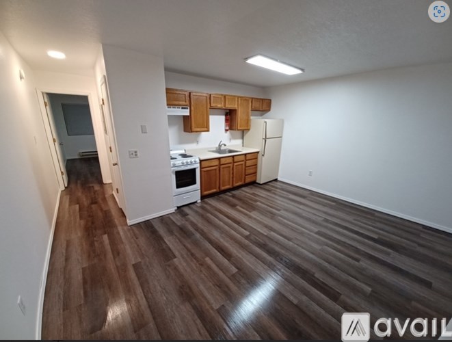 A kitchen with wooden floors and white walls.