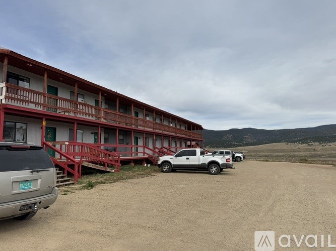 A large building with a balcony and a car parked in front.