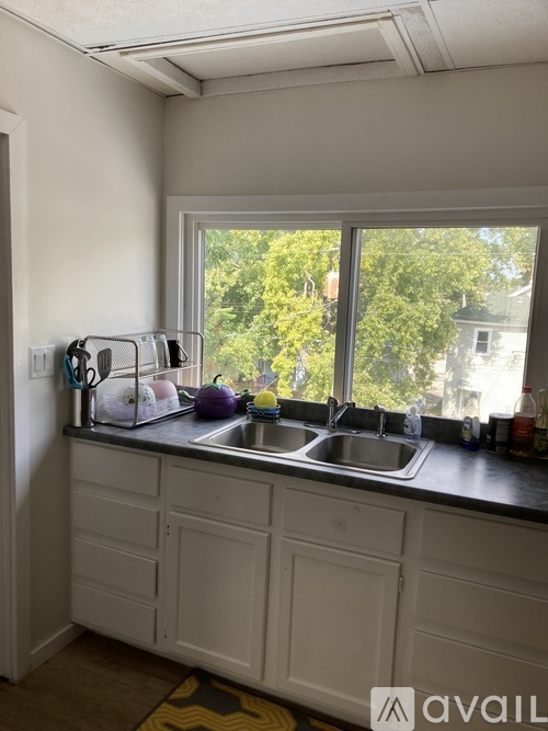 A kitchen with a stove, sink, and cabinets.