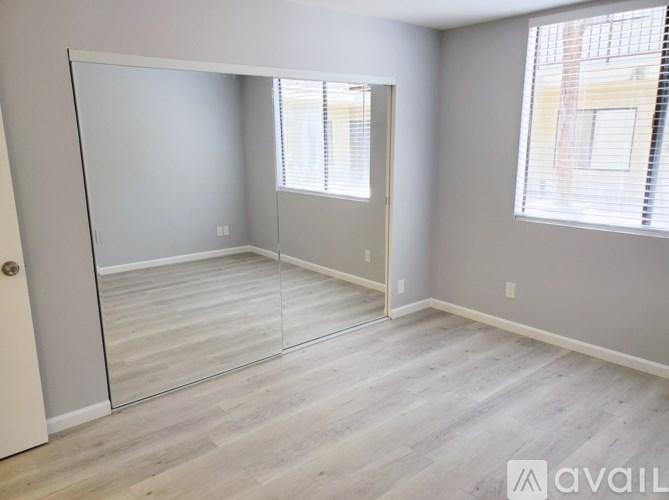A room with a sliding glass door and wooden flooring.