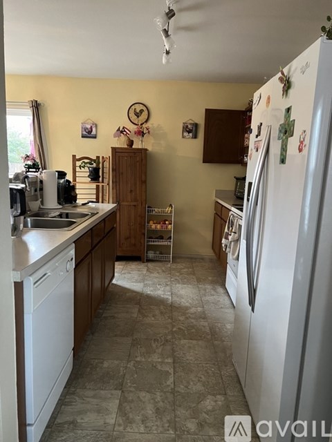 A kitchen with a white refrigerator and a white dishwasher.