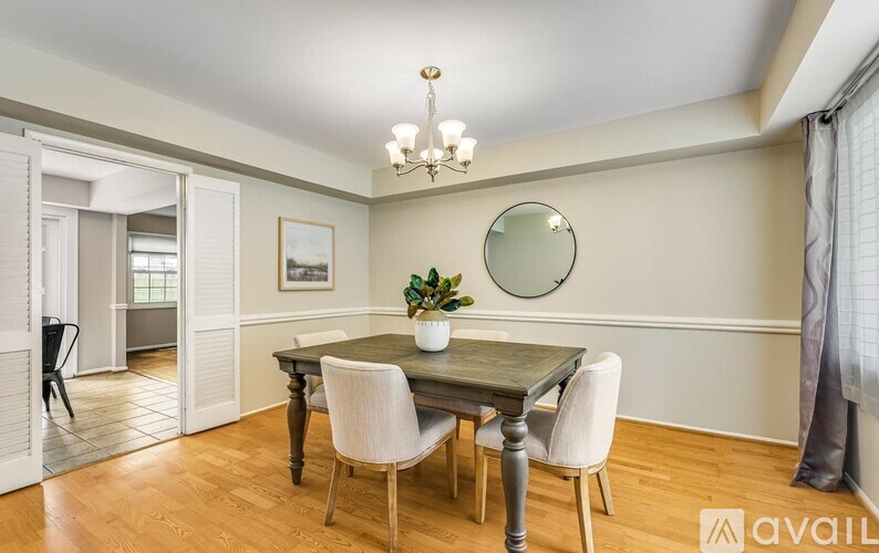 A dining room with a wooden table and chairs.