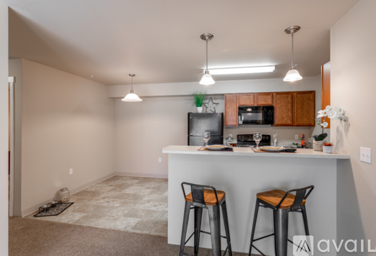 A kitchen with a bar stool and a fridge.