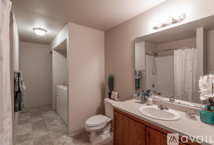 A bathroom with a toilet, sink, and mirror.
