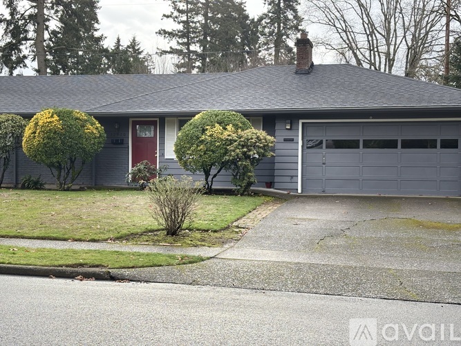A house with a red door and a grey garage door.