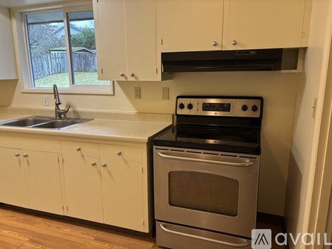 A kitchen with white cabinets and a stainless steel oven.