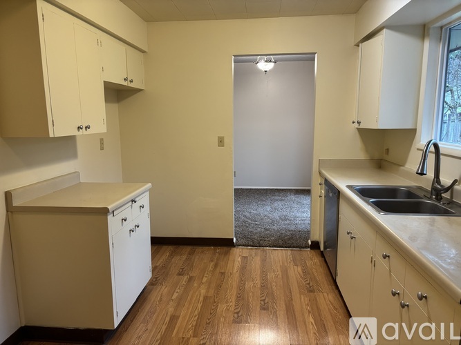 A kitchen with wooden floors and white appliances.