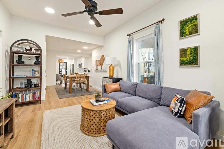 A living room with a grey couch and a wooden coffee table.