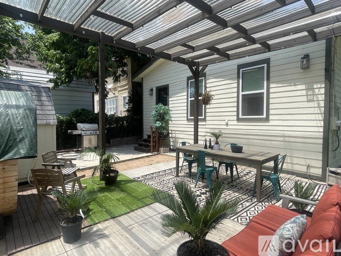 A patio with a table and chairs under a roof.