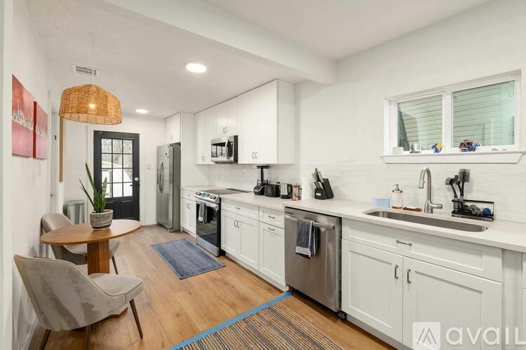 A modern kitchen with white cabinets and stainless steel appliances.