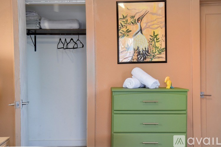 A green dresser with a yellow rubber ducky on top of it.