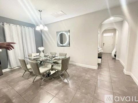 A dining room with a glass table and chairs.