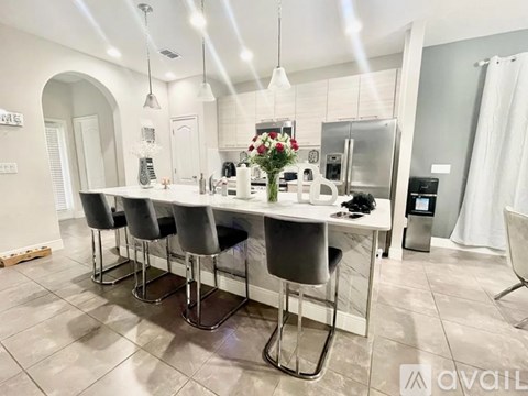 A kitchen with a table and chairs.