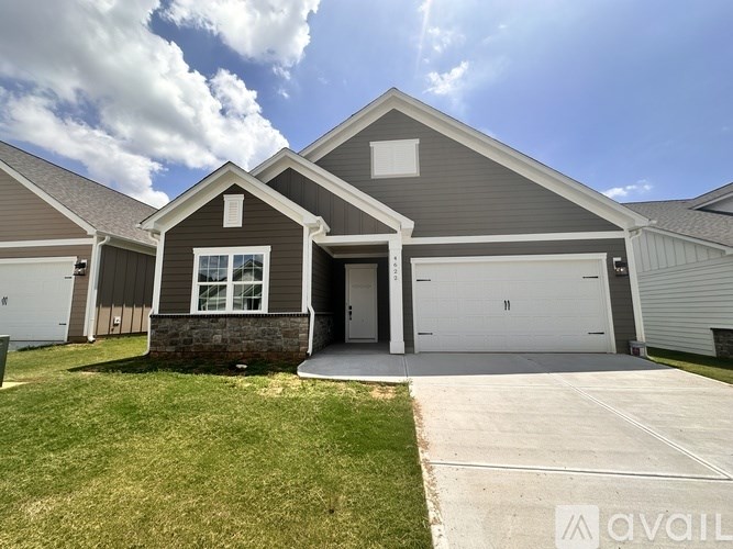 A house with a grey roof and a white garage door.