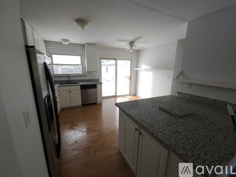 A kitchen with a black fridge and a counter top.