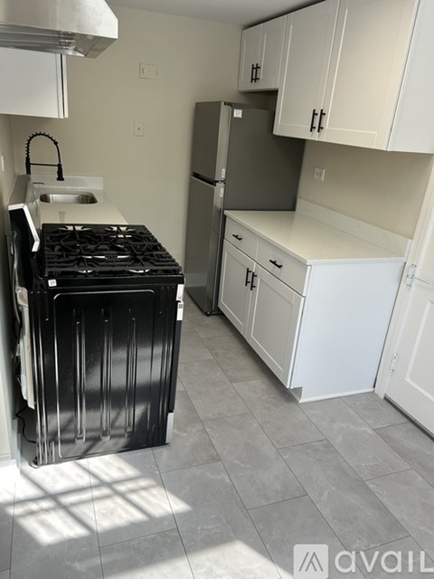 A kitchen with a black stove top oven and white cabinets.