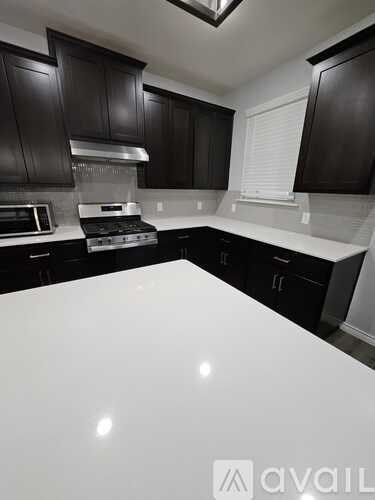 A kitchen with black cabinets and a white countertop.
